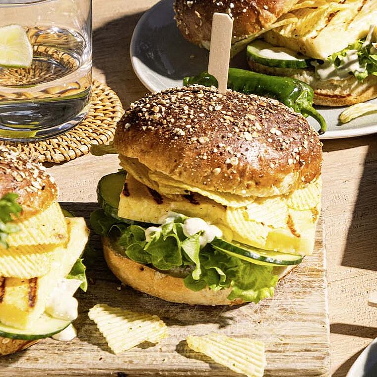 Grillkäse-Burger mit crunchy Lay's Chips Sour Cream and Onion,  Salat, gegrillten Lauchzwiebeln und grüner Kräutersoße