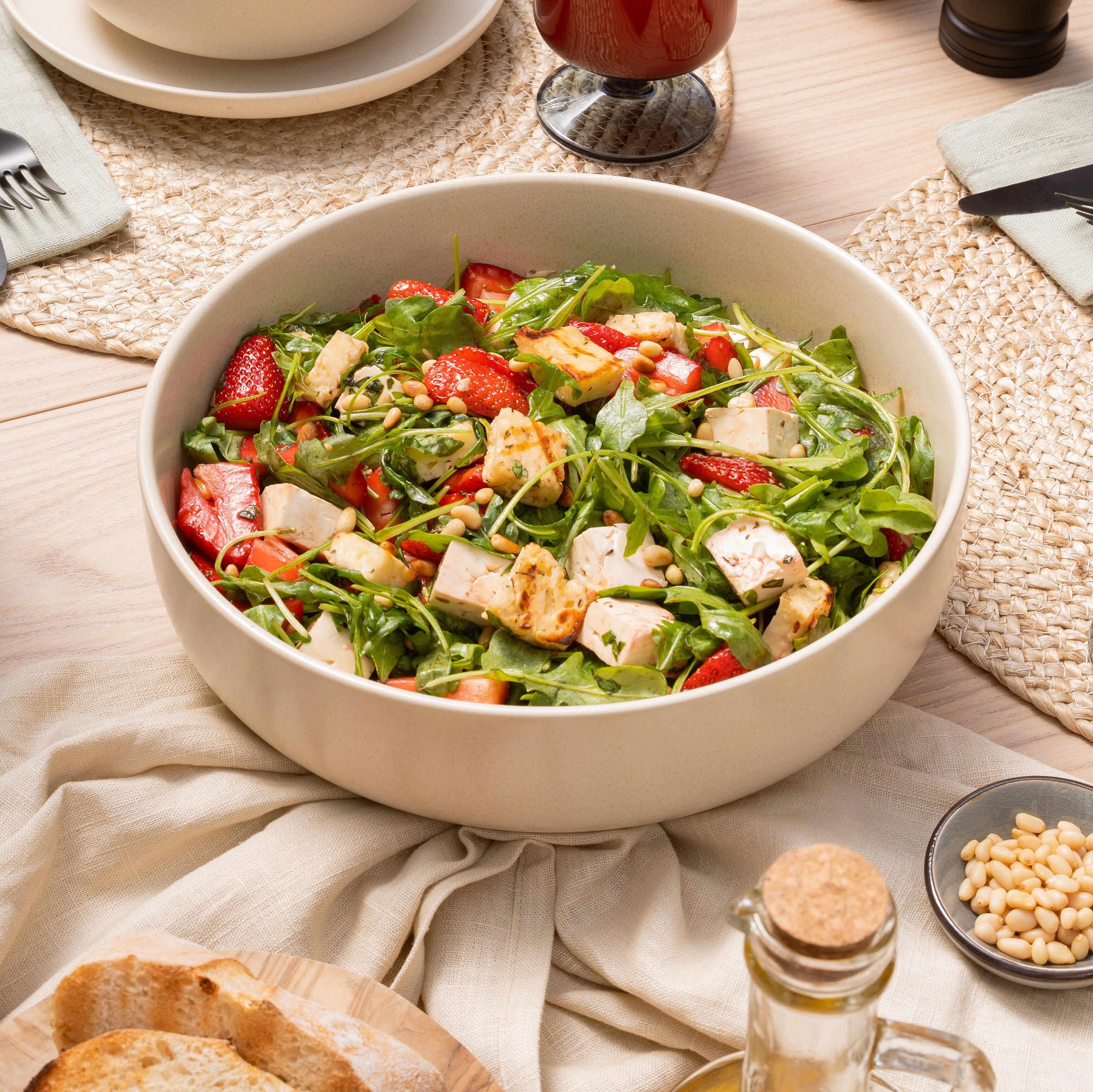 Summer table setting with a strawberry arugula salad, grilled cheese, white cheese, and fresh strawberries.