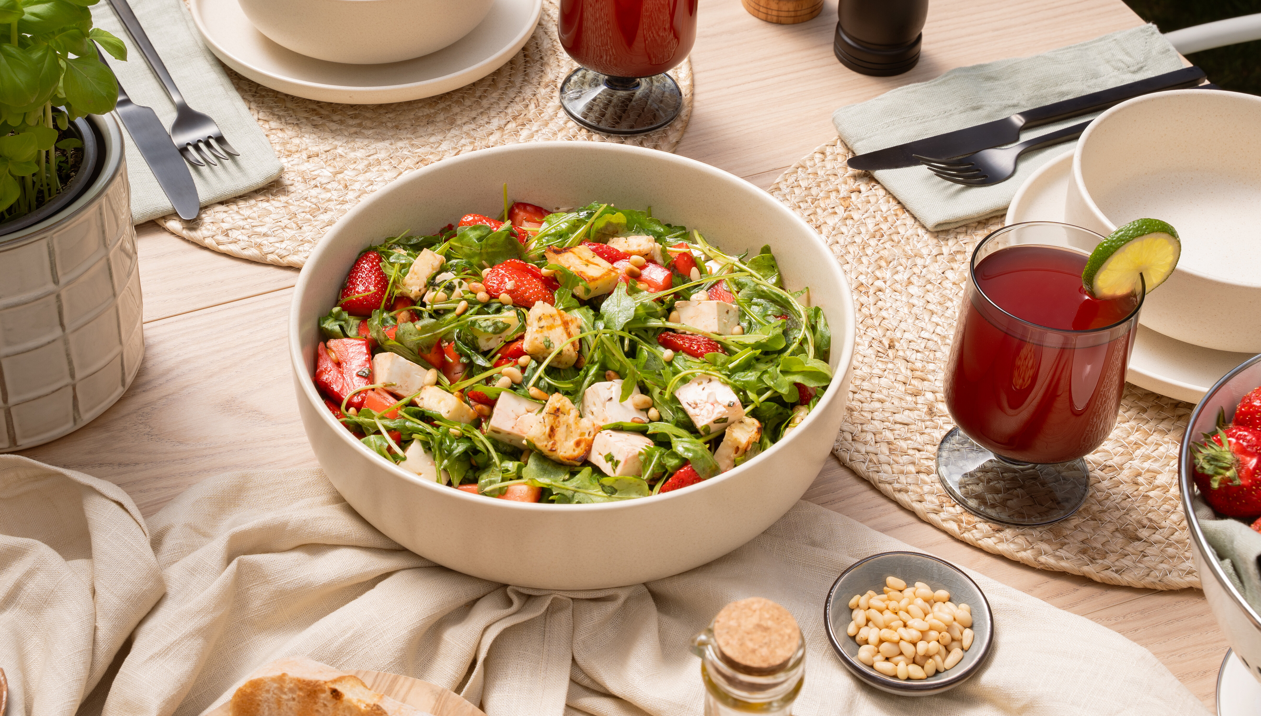 Summer table setting with a strawberry arugula salad, grilled cheese, white cheese, and fresh strawberries.