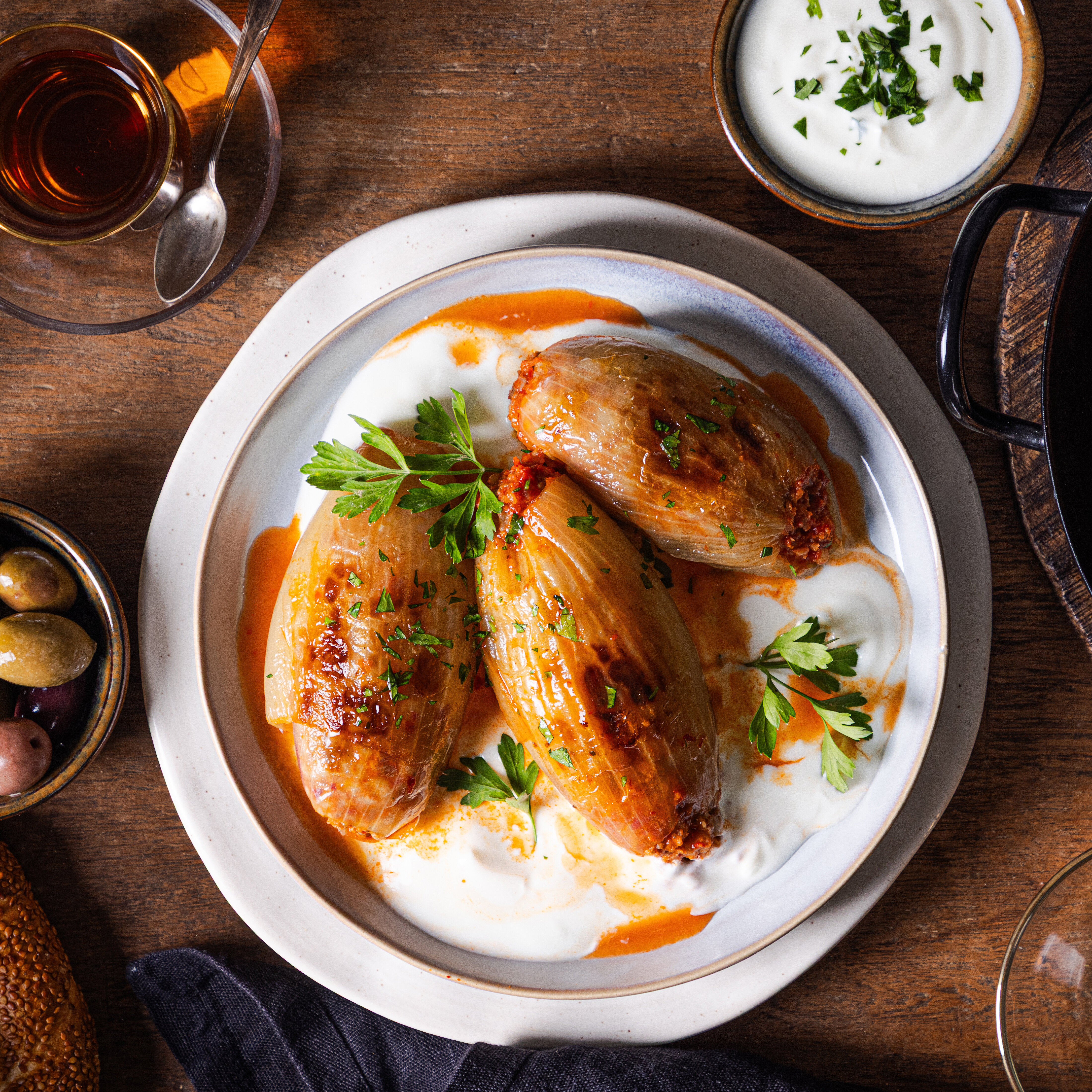 [Translate to Türkisch:] Gefüllte Zwiebeln (Soğan Dolması) mit Joghurt und Petersilie auf einem Teller