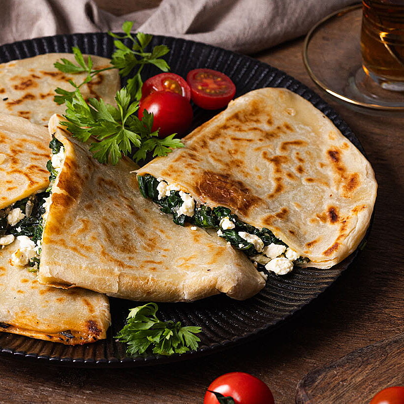 Türkische Gözleme mit Schafkäse und Kashkaval, goldbraun gebraten und auf einem Teller serviert