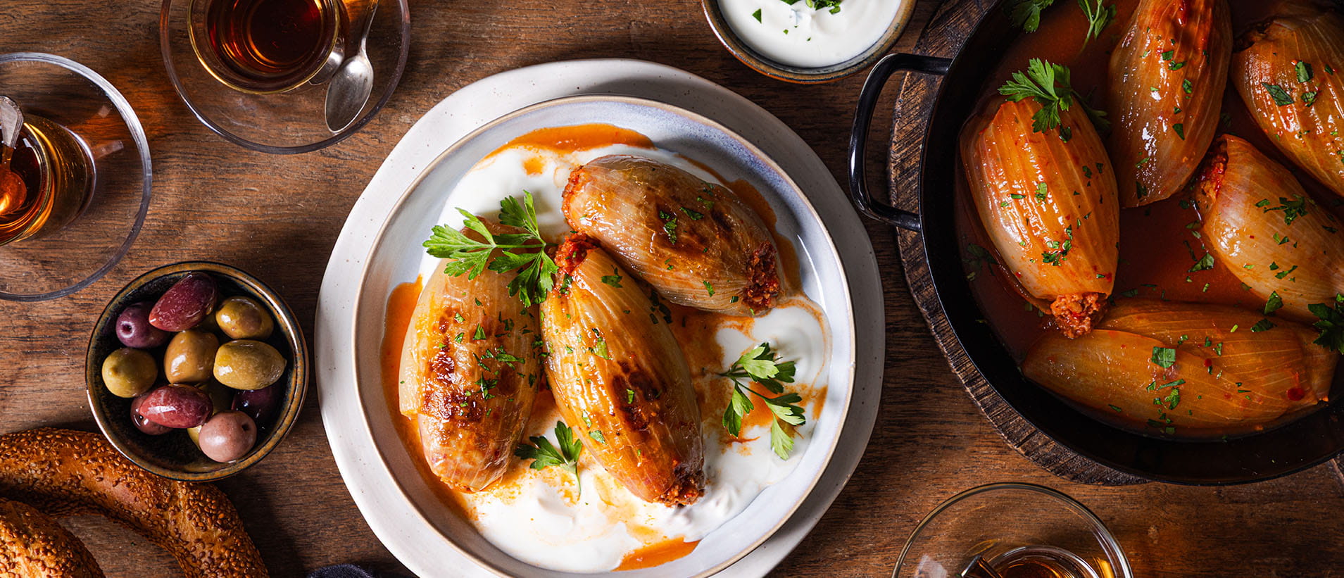 [Translate to Türkisch:] Gefüllte Zwiebeln (Soğan Dolması) mit Joghurt und Petersilie auf einem Teller