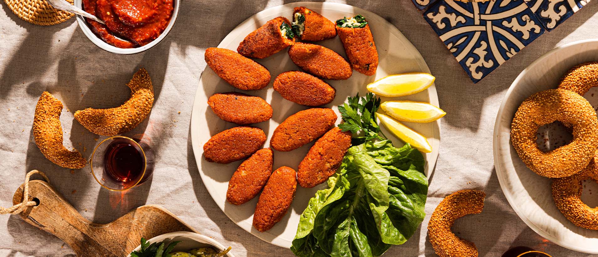 Köfte with kashkaval spinach filling fried until golden brown and served on a plate with spinach and lemons